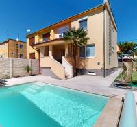Ein Einfamilienhaus in Komárno mit einem Pool, einer Liege und einer Gartenschaukel im Garten.