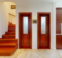 Treppe, Türen und Küche im Inneren eines Einfamilienhauses mit Holzelementen.