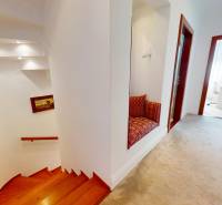 Ein Flur mit einer Treppe, einer Sitznische und eleganten Holzrahmen in einem Einfamilienhaus.