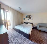 Schlafzimmer in einer 2-Zimmer-Wohnung mit Bett, Sofa und Balkon.