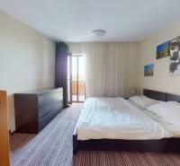 Helles Schlafzimmer in einer 2-Zimmer-Wohnung mit großem Bett, Schrank und Dekoration.