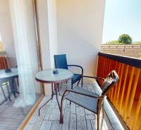 Ein Balkon in einer 2-Zimmer-Wohnung mit Blick auf die umliegende Natur und Dächer.