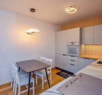 Küche in einer 3-Zimmer-Wohnung mit hellen Möbeln und Holzboden.