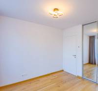 Ein Zimmer mit Holzboden und einem eingebauten Schrank in einer 3-Zimmer-Wohnung.