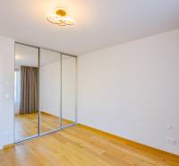 Ein Zimmer mit Holzboden, einem Spiegelschrank und einem Vorhang in einer 3-Zimmer-Wohnung.