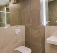 Badezimmer mit hängender Toilette und Duschkabine in einer 3-Zimmer-Wohnung.