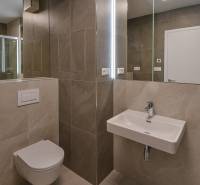 Badezimmer mit hängendem WC, Waschbecken und Dusche in einer 3-Zimmer-Wohnung.