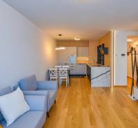 Wohnzimmer in einer 3-Zimmer-Wohnung mit Küche, helle Holzböden und bequeme Sitzgelegenheiten.