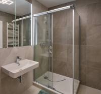 Badezimmer mit Dusche und Spiegel in einer 3-Zimmer-Wohnung.