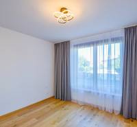 Unmöbliertes Zimmer mit Holzboden und Vorhängen in einer 3-Zimmer-Wohnung.
