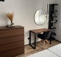 Schlafzimmer mit Kommode, Spiegel und Schreibtisch in einer 3-Zimmer-Wohnung.