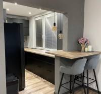 Stilvolle Küche mit Holzboden und Bartresen in einer 3-Zimmer-Wohnung.