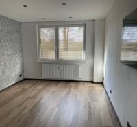 Wohnzimmer in einer 3-Zimmer-Wohnung mit grauen Wänden und hellen Böden.