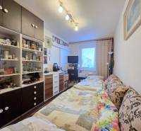 Ein Zimmer in einer 3-Zimmer-Wohnung mit einem Schrank, einem Bett und dekorativen Gegenständen.
