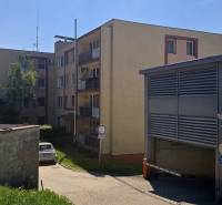 Ein Wohnhaus in der Bárdošova-Straße in Bratislava, Kramáre, umgeben von Grünflächen und einem Parkplatz.