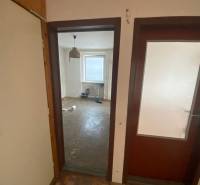 Ein Zimmer in einer 3-Zimmer-Wohnung mit nacktem Boden und einem Fenster.
