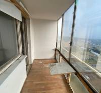Veranda mit Glasfenstern und Holzboden in einer 3-Zimmer-Wohnung, mit Blick auf das Äußere.
