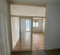 Das Interieur einer 3-Zimmer-Wohnung mit Parkettboden und einem großen Fenster.