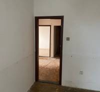 Eine leere Inneneinrichtung mit offenen Türen und Parkettboden in einer 3-Zimmer-Wohnung.