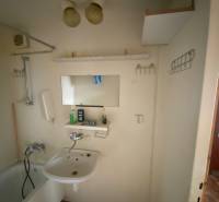 Badezimmer mit Badewanne und Waschbecken in einer 3-Zimmer-Wohnung mit Ablagefächern.