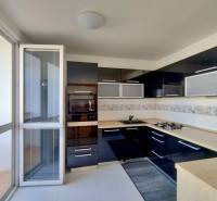 Küche mit dunklen Schränken und eingebauten Geräten in einer 3-Zimmer-Wohnung.