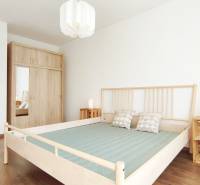 Schlafzimmer mit Holzbett, Einbauschrank und Nachttischen in einer 2-Zimmer-Wohnung.