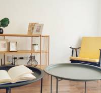 Innenraum einer 2-Zimmer-Wohnung mit dekorativen Elementen, einem Stuhl und einem Tisch mit einem Buch.