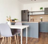 Küche mit Esstisch und Stühlen, 2-Zimmer-Wohnung mit Holzboden und Dekoration.
