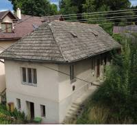 Ein Einfamilienhaus unter dem Bôd Bánoš in Banská Bystrica mit einem schrägen Dach und einem Garten.