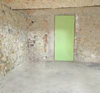 Wände aus Stein mit unverputzten Ziegeln und Türen in einem Einfamilienhaus.