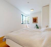 Helles Schlafzimmer in einem Einfamilienhaus mit großem Fenster, Bild und Pflanze.