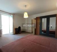Geräumiges Zimmer in einer Einzimmerwohnung mit Bett, Schrank und Balkontüren.