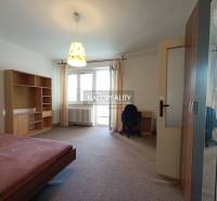 Schlafzimmer in einer Einzimmerwohnung mit Einbauschrank und Schreibtisch.