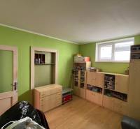 Ein Zimmer in einem Einfamilienhaus mit Holzmöbeln und grünen Wänden.