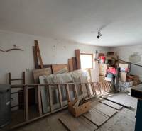 Unordnung in einem Raum eines Einfamilienhauses mit gelagerten Schränken, Kisten und Holzrahmen.