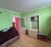 Ein Zimmer in einem Einfamilienhaus mit Holzmöbeln und grünen Wänden.