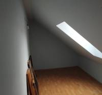 Dachzimmer mit Holzboden und Dachfenster in einem Einfamilienhaus.