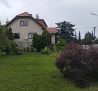 Ein Einfamilienhaus in Martin, mit einem gepflegten Garten und umgeben von Bäumen und Sträuchern.