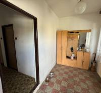 Der Flur eines Einfamilienhauses mit einem Korb aus Weidengeflecht, einem Schrank und Vorhängen.