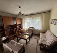 Wohnzimmer in einem Einfamilienhaus mit Sofa, Teppich, Wand mit Schränken.