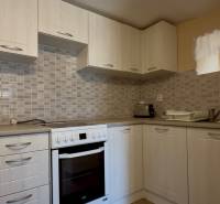 Praktische Küche in einem Einfamilienhaus mit weißen Schränken und Geräten.