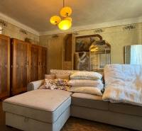 Wohnzimmer in einem Einfamilienhaus mit großem Sofa, Schränken, Vintage-Dekorationen, warmem Licht.