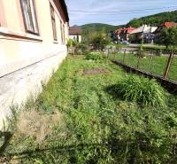 Der Garten des Einfamilienhauses in Nitrianske Sučany mit Blick auf die Straße und die Hügel.