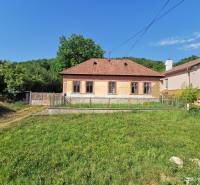 Ein Einfamilienhaus in der Straße in Nitrianske Sučany, umgeben von einem grünen Grundstück und Natur.