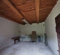 Die Holzdecke im Raum eines Einfamilienhauses mit einfacher Einrichtung und weißen Wänden.