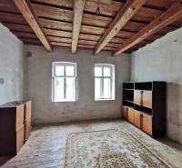Ein Zimmer in einem Einfamilienhaus mit Holzdecke, Fenster, Schränke, Teppich auf dem Boden.