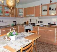 Eine Küche in einem Einfamilienhaus mit einer Holzarbeitsplatte, einem Esstisch und Blumendekoration.