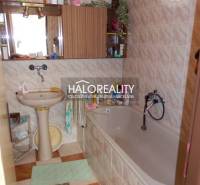Badezimmer in einem Einfamilienhaus mit Badewanne, Waschbecken und Spiegel.