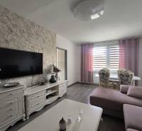 Wohnzimmer in einer 3-Zimmer-Wohnung mit Fernseher, Sofa und Esstisch.