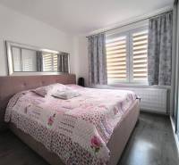 Schlafzimmer in einer 3-Zimmer-Wohnung mit einem großen Bett und einer Blumenüberdecke.